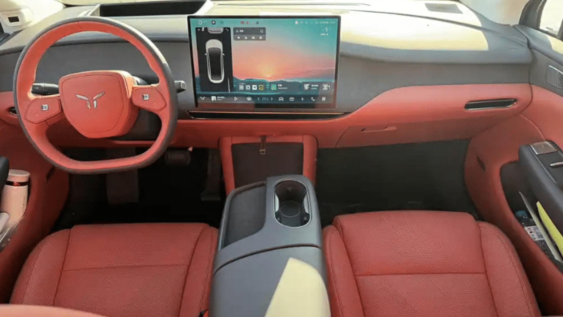 Interior of a modern car with red leather seats and large touchscreen display